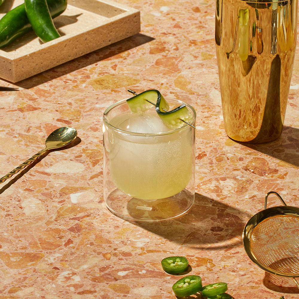 Nowadays Chilled Heat THC Infused Drink with cucumber garnish on textured counter top