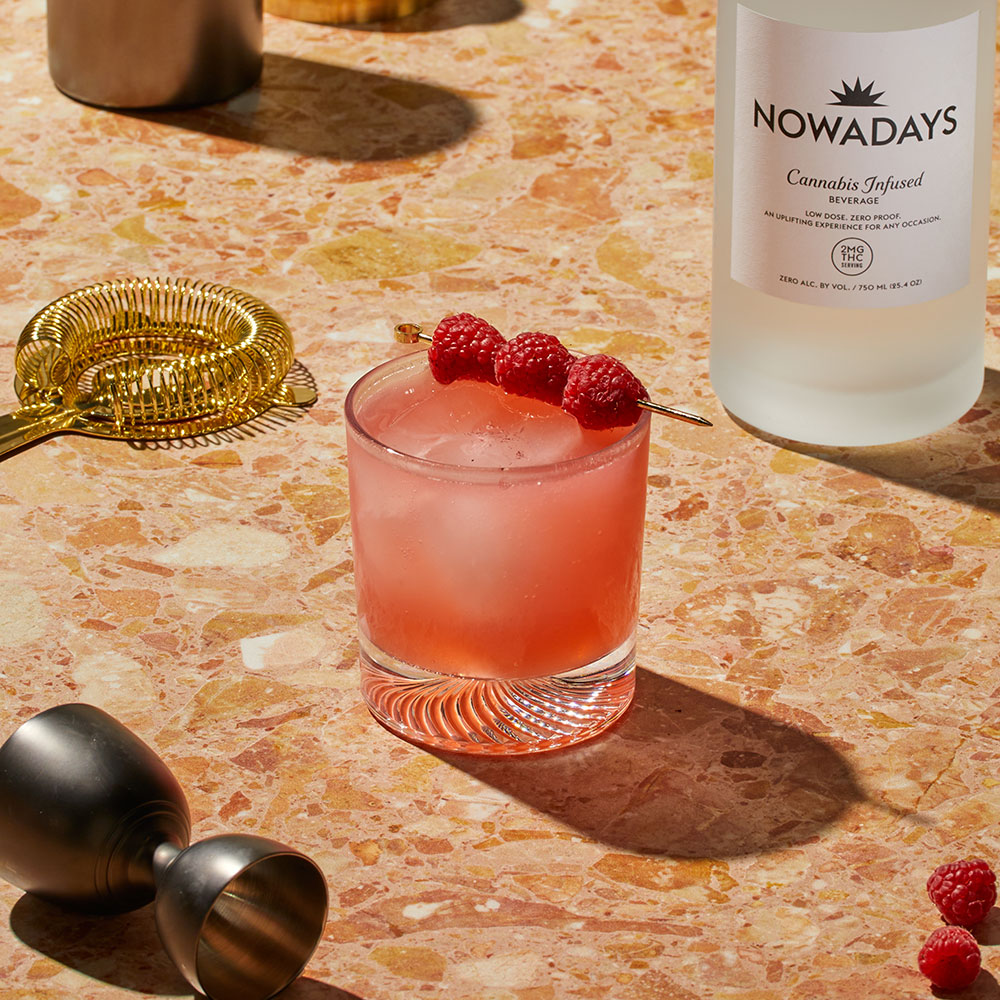 Nowadays Razzle Dazzle THC Infused Juice with berry garnish on textured counter top